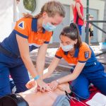 First Aid - woman in blue t-shirt and blue pants holding baby