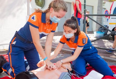 First Aid - woman in blue t-shirt and blue pants holding baby