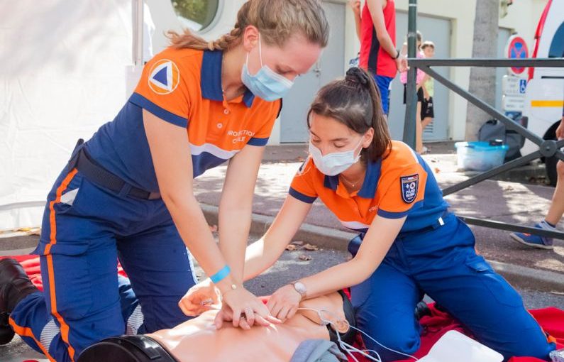 First Aid - woman in blue t-shirt and blue pants holding baby