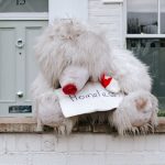 Pet Loss - white animal plush toy on gray concrete wall on top