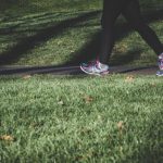 Health Nutrition - shallow focus photography of person walking on road between grass