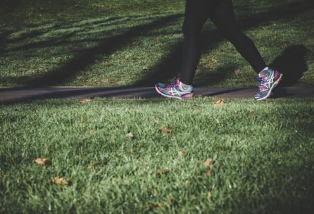 Health Nutrition - shallow focus photography of person walking on road between grass