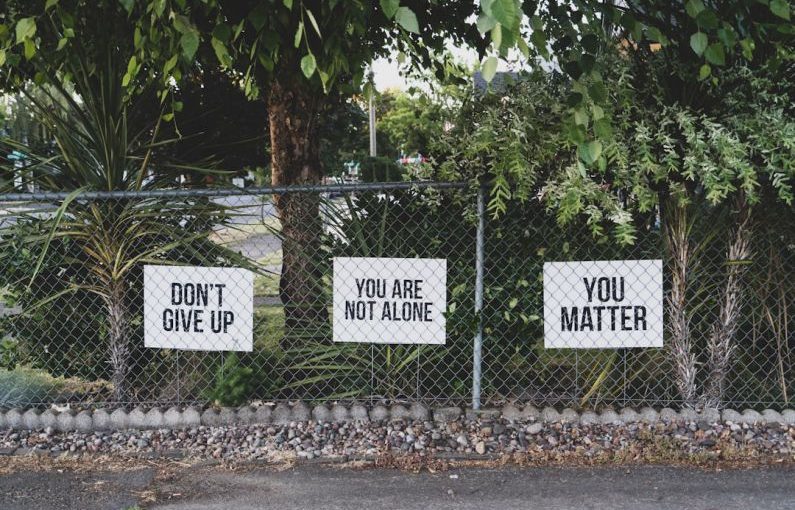 Mental Stimulation - don't give up. You are not alone, you matter signage on metal fence