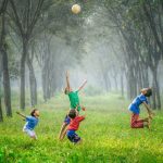 Fun Activities - four boy playing ball on green grass