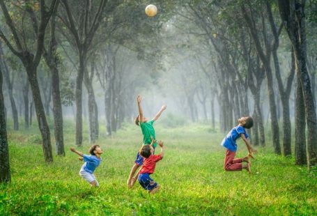 Fun Activities - four boy playing ball on green grass