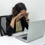 Health Issues - a woman sitting in front of a laptop computer