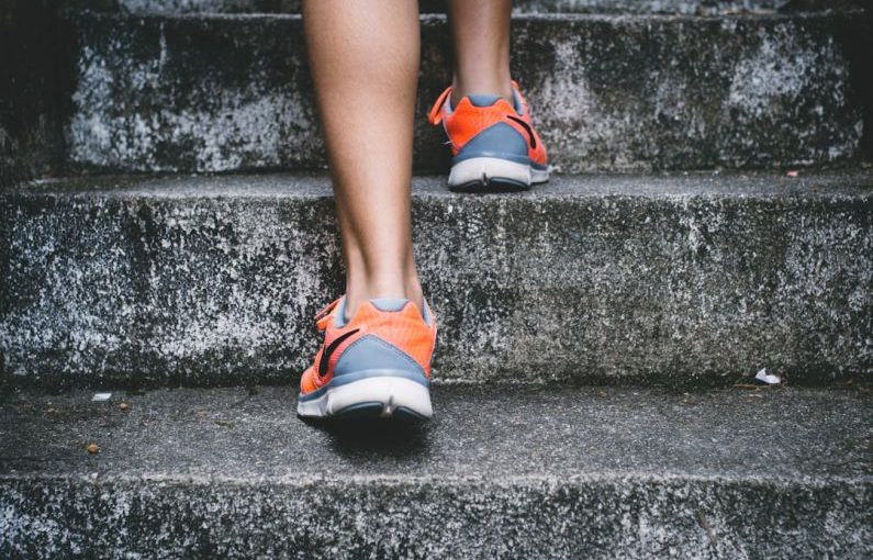 Exercise Health - person wearing orange and gray Nike shoes walking on gray concrete stairs
