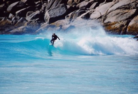 Challenges Exotic - a man riding a wave on top of a surfboard