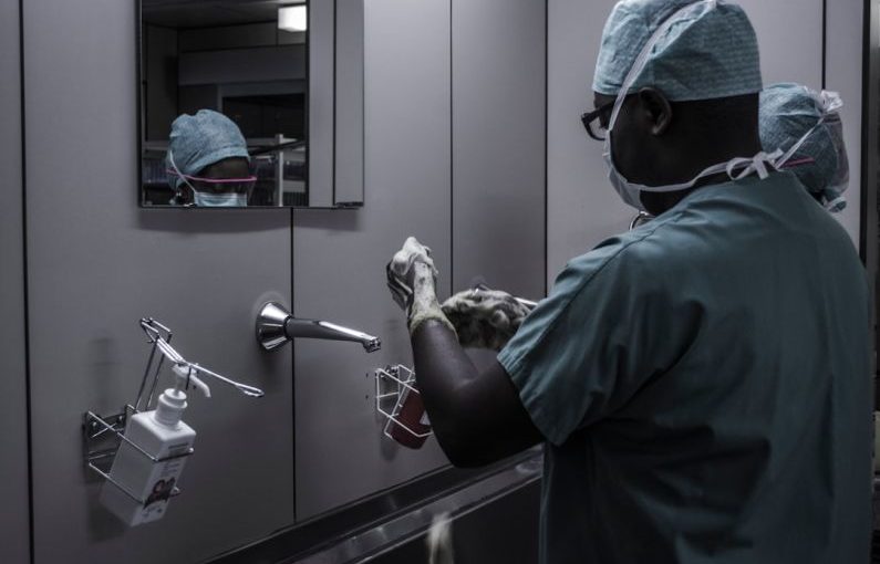 Hygiene Exotic - man wearing surgical suit near mirror