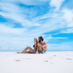 Travel Exotic - man sitting beside of woman in black bikini top