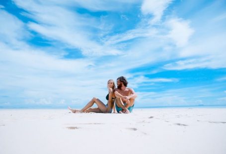 Travel Exotic - man sitting beside of woman in black bikini top