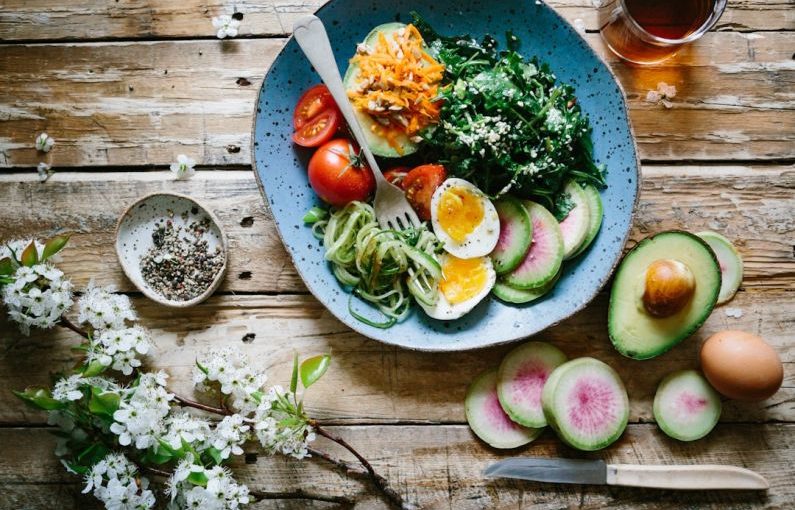 Balanced Diet - poached egg with vegetables and tomatoes on blue plate