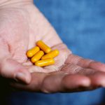 Supplements Pets - yellow medication pill on persons hand