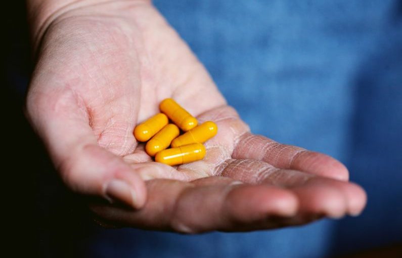 Supplements Pets - yellow medication pill on persons hand