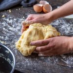 Homemade Food - person holding bread on brown wooden table