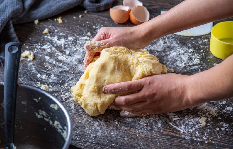 Homemade Food - person holding bread on brown wooden table