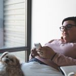 Pet Obesity - person holding smartphone beside dog