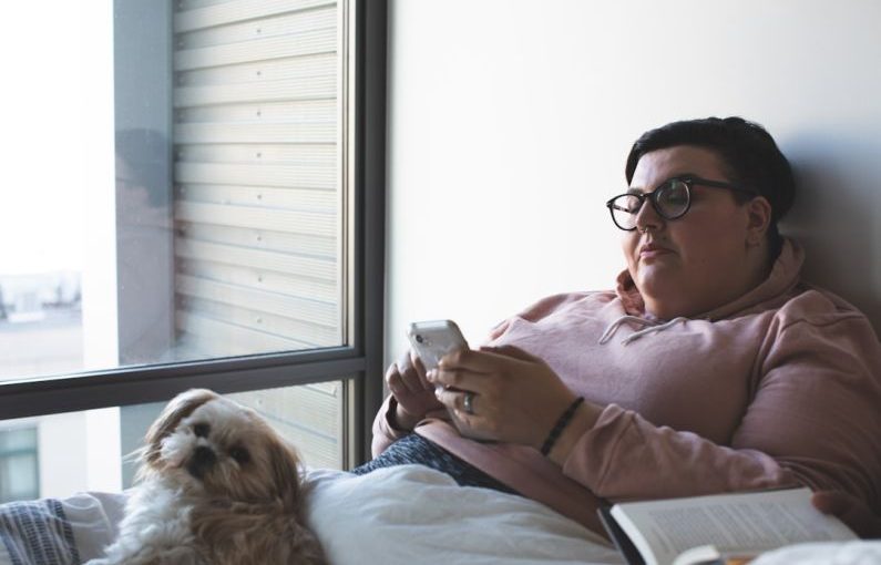 Pet Obesity - person holding smartphone beside dog