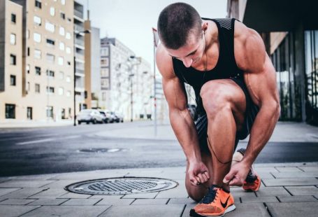 Exercise Benefits - man tying his shoes