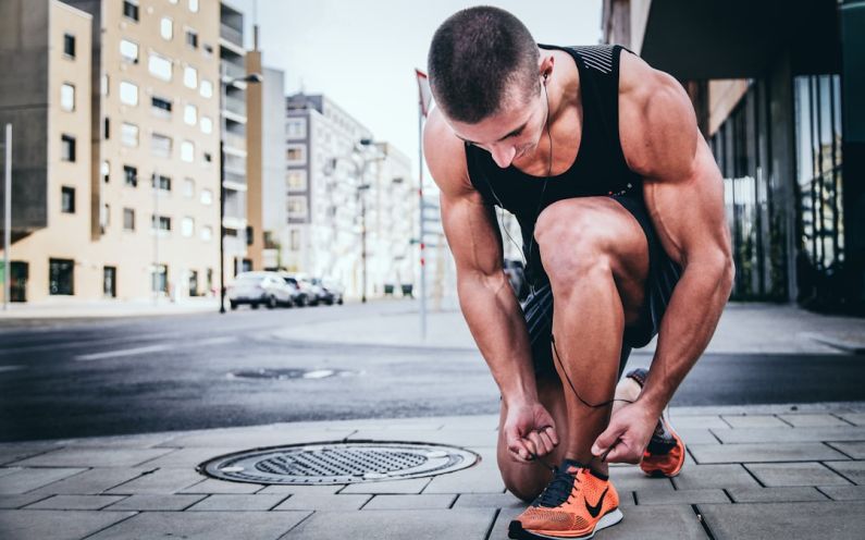 Exercise Benefits - man tying his shoes